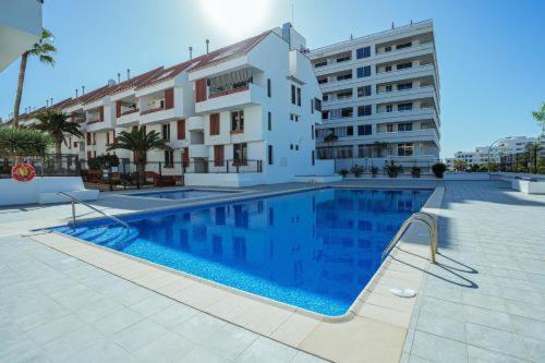 a large swimming pool in front of a building at Duplex Las Americas in Playa de las Americas