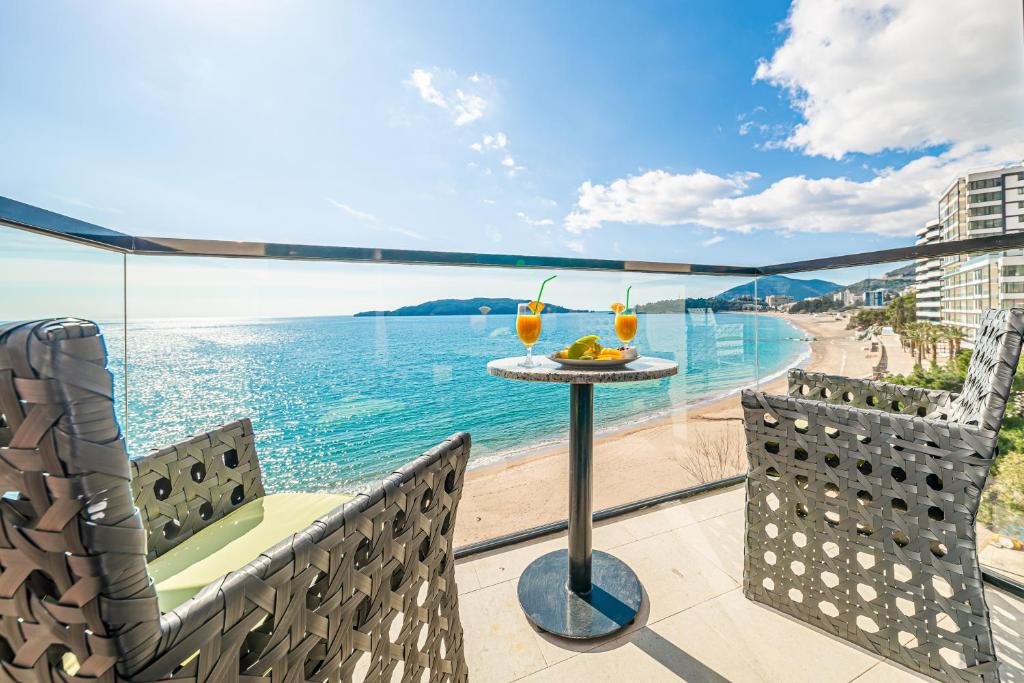 balcón con mesa y sillas y vistas a la playa en Hotel Aleksandar Rafailovići, en Budva