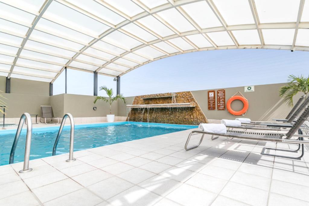 uma piscina interior com tecto de vidro em Costa del Sol Wyndham Chiclayo em Chiclayo