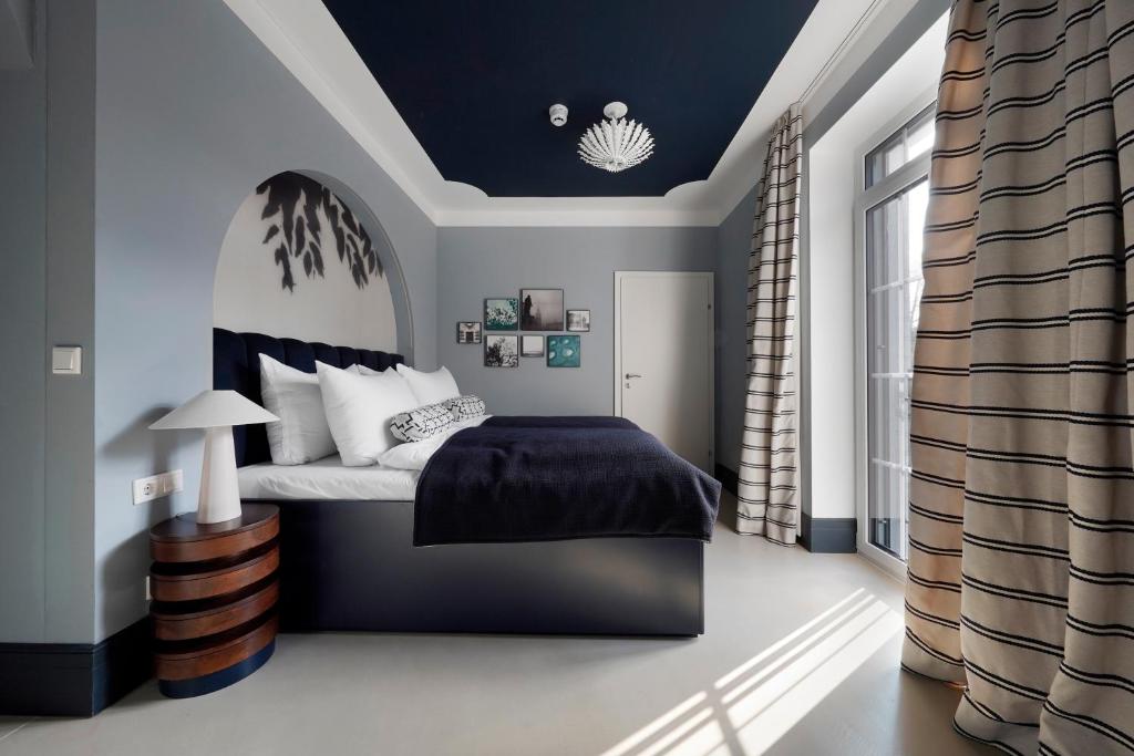 薩爾斯堡的住宿－numa I Maximilian，一间卧室配有一张蓝色天花板的床