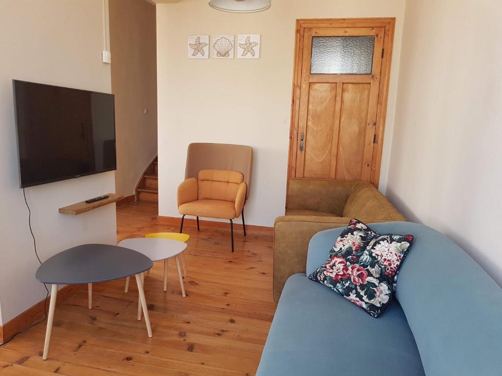 un salon avec un canapé et une télévision dans l'établissement Apt 6 pers. Duplex vue mer avec charme de l'ancien, à Bray-Dunes