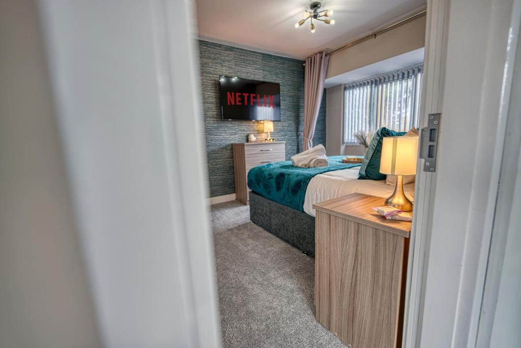a hotel room with a bed and a television at Stylish House - B'ham Airport and NEC, JLR Solihull, Business & Leisure Stays - Aspen House in Solihull