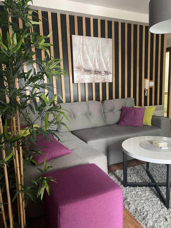 a living room with a gray couch and purple pillows at Apartman KulTurista in Zlatibor