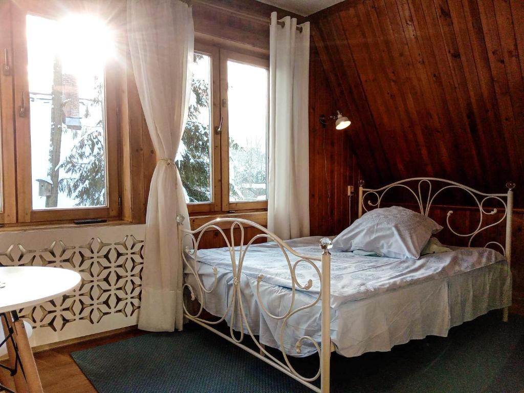 a bedroom with a metal bed with a window at Willa Kasprusie in Zakopane