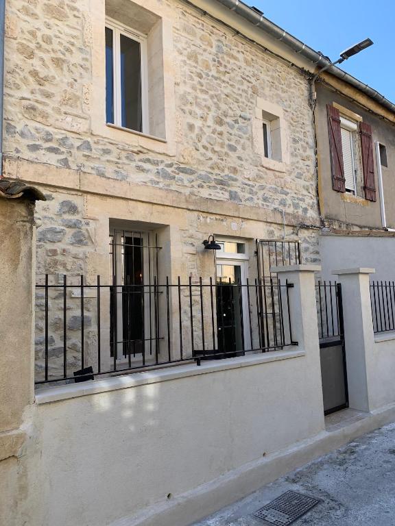 un bâtiment avec une clôture devant lui dans l'établissement Arles : maison de ville a deux pas de tour Luma, à Arles