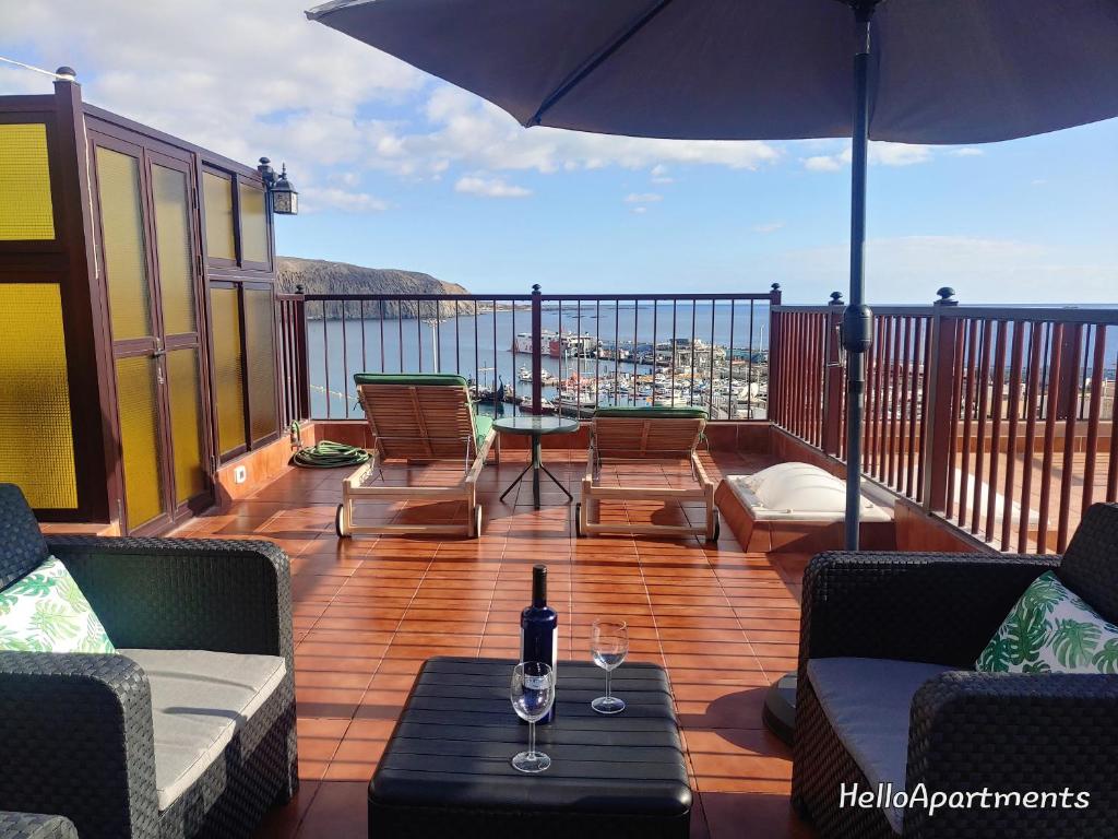 een terras met stoelen en een tafel en een parasol bij Sun Terrace Los Cristianos by HelloApartments in Los Cristianos