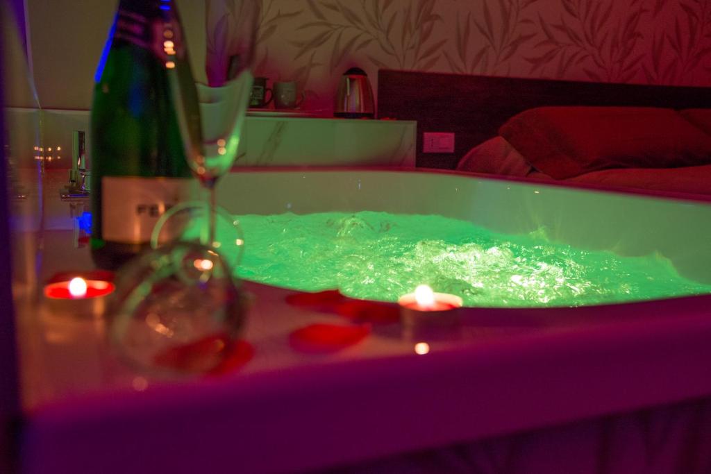 - une baignoire verte avec une bouteille de vin et un verre dans l'établissement B&B Erifrà Piccolo Hotel, à Cosenza