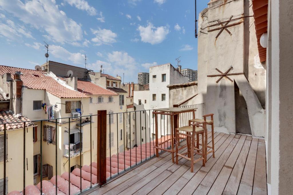 a balcony with a table and chairs on a building at #LaFrenchCasa Belsunce in Marseille