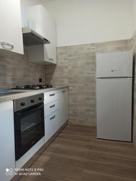 a kitchen with white appliances and a white refrigerator at Franca in Lonate Ceppino