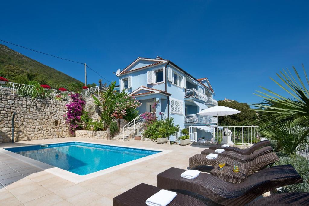 a villa with a swimming pool and a house at Villa Bella Vista - apartments in Labin