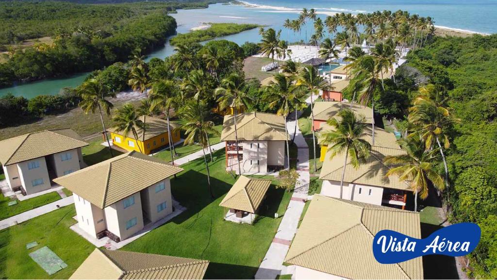 een luchtzicht op een huis met palmbomen en de oceaan bij Asenza Beach Resort All Inclusive in Pitimbu