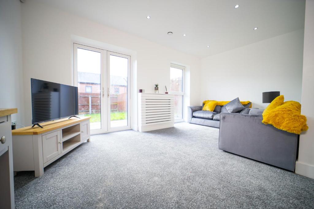 uma sala de estar com um sofá e uma televisão em 3 bedroom house in Birmingham City centre - Sleeps 6 (Netflix included) em Birmingham