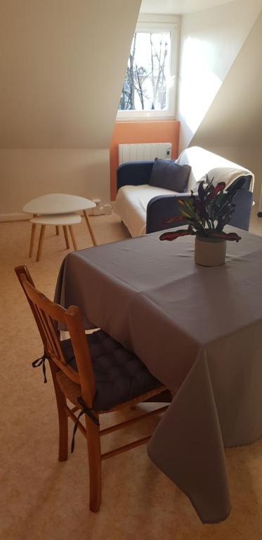 Habitación con mesa, silla y sofá en hebergement-luxeuil-les-bains, en Luxeuil-les-Bains