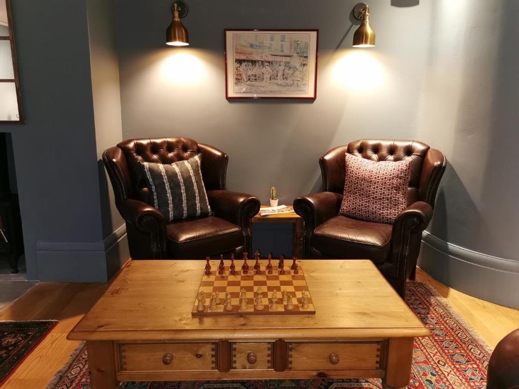 a room with two chairs and a chessboard on a table at The Vines Hotel in Alvescot