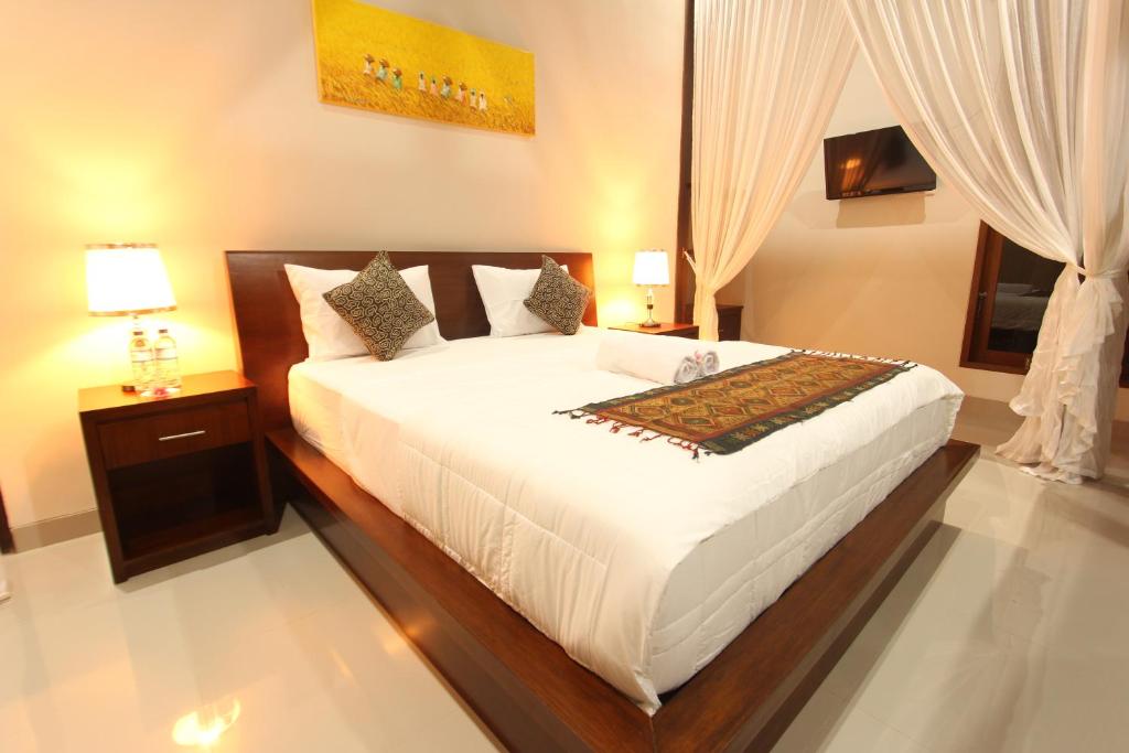 a bedroom with a large white bed and a window at Mahanadewi Villa in Ubud