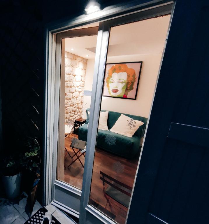 - un miroir avec un canapé dans le salon dans l'établissement Lovers' Tiny House inside Montmartre, à Paris