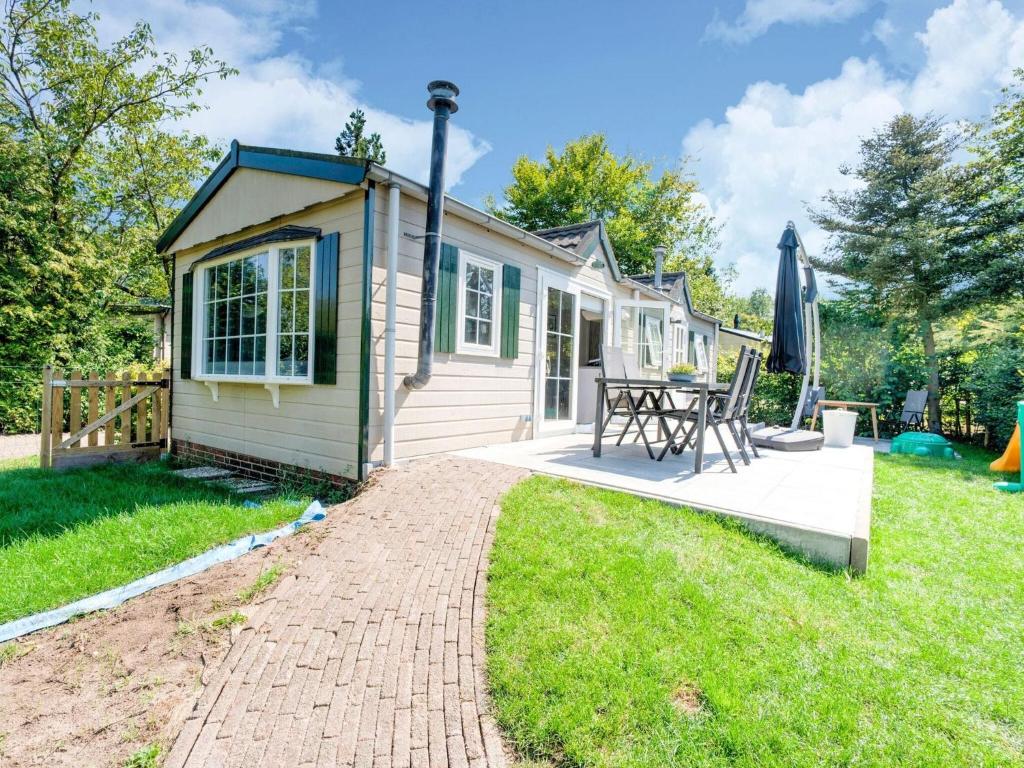 a tiny house with a patio and a table at Charming Chalet in Stegeren near Forest in Stegeren