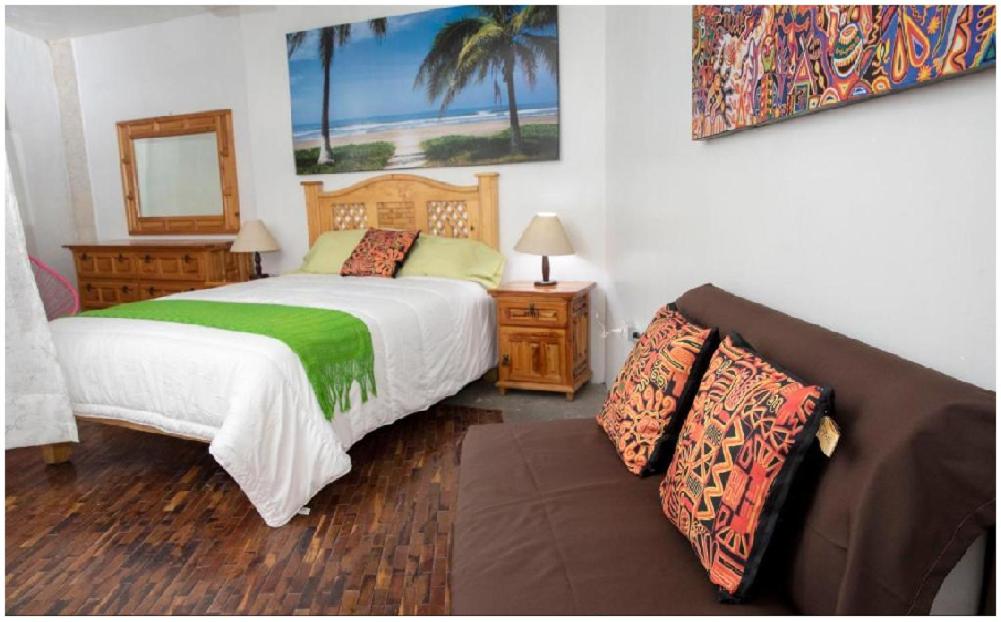 una camera con letto, divano e specchio di Hostel St Llorenc a Città del Messico
