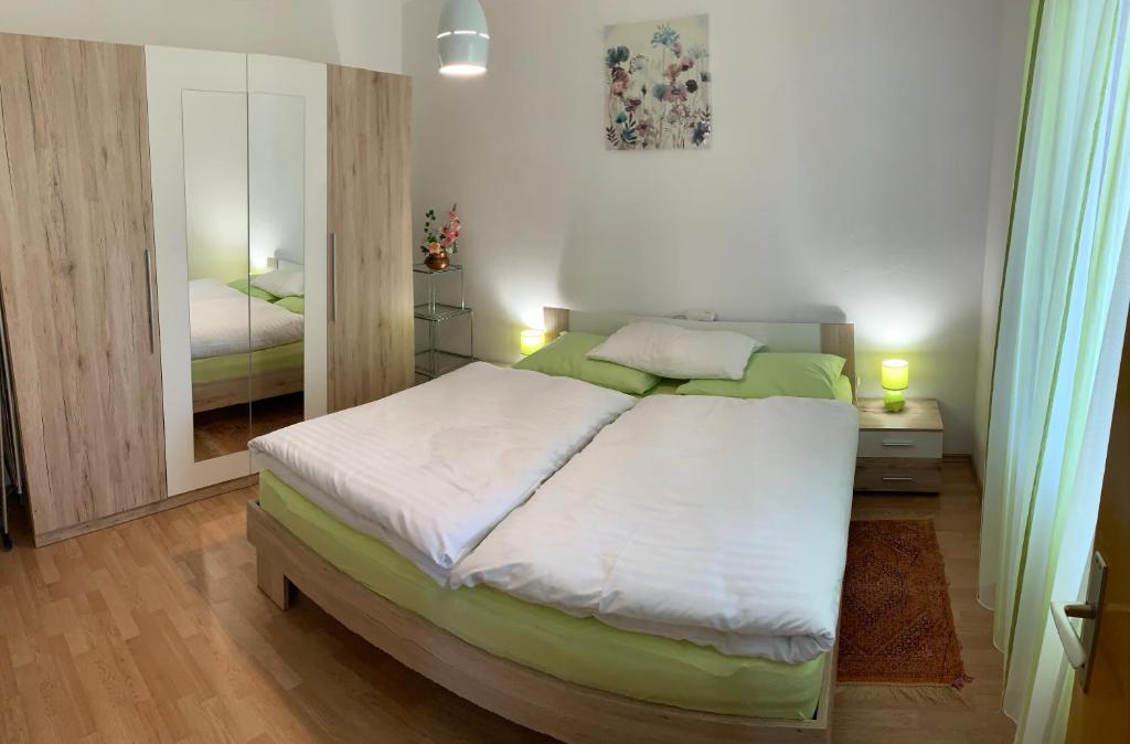 - une chambre avec un grand lit et un miroir dans l'établissement Apartment "Onkel", à Šibenik