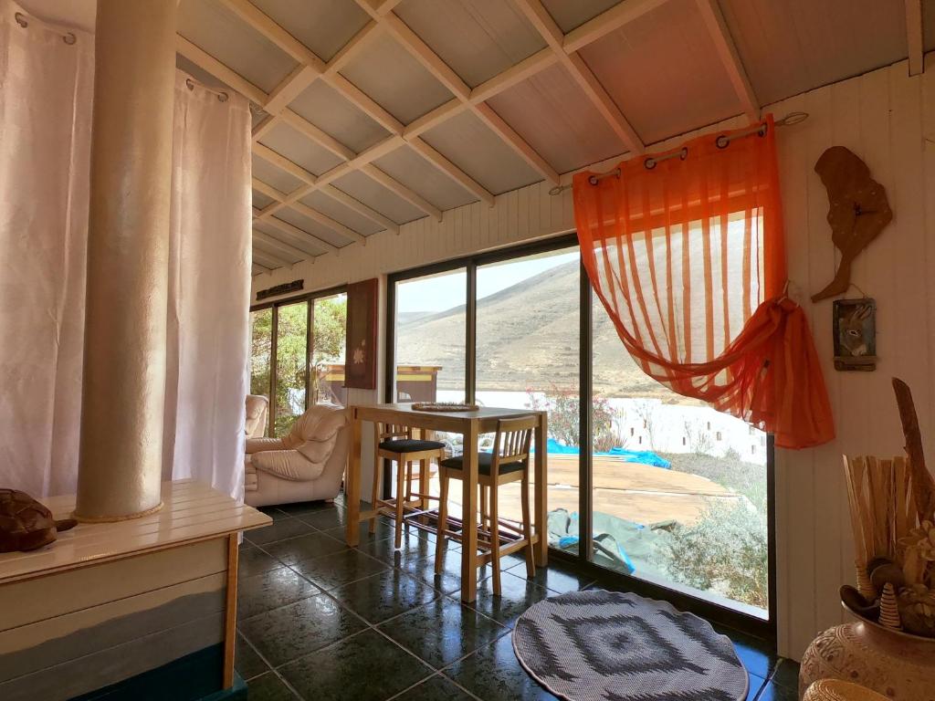 Cette chambre dispose d'une grande fenêtre et d'une table avec des chaises. dans l'établissement Kikiki House, à Puerto del Rosario