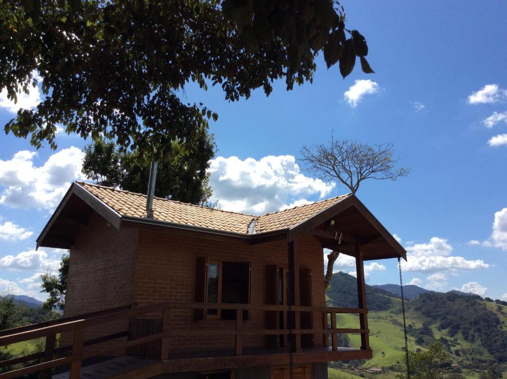 uma pequena casa com um telhado numa colina em Chalé Recanto Lobo Guará em Gonçalves