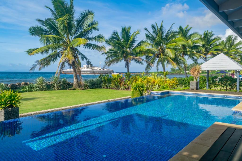 einen Pool mit Meerblick und ein Kreuzfahrtschiff in der Unterkunft Aroha Taveuni in Waiyevo