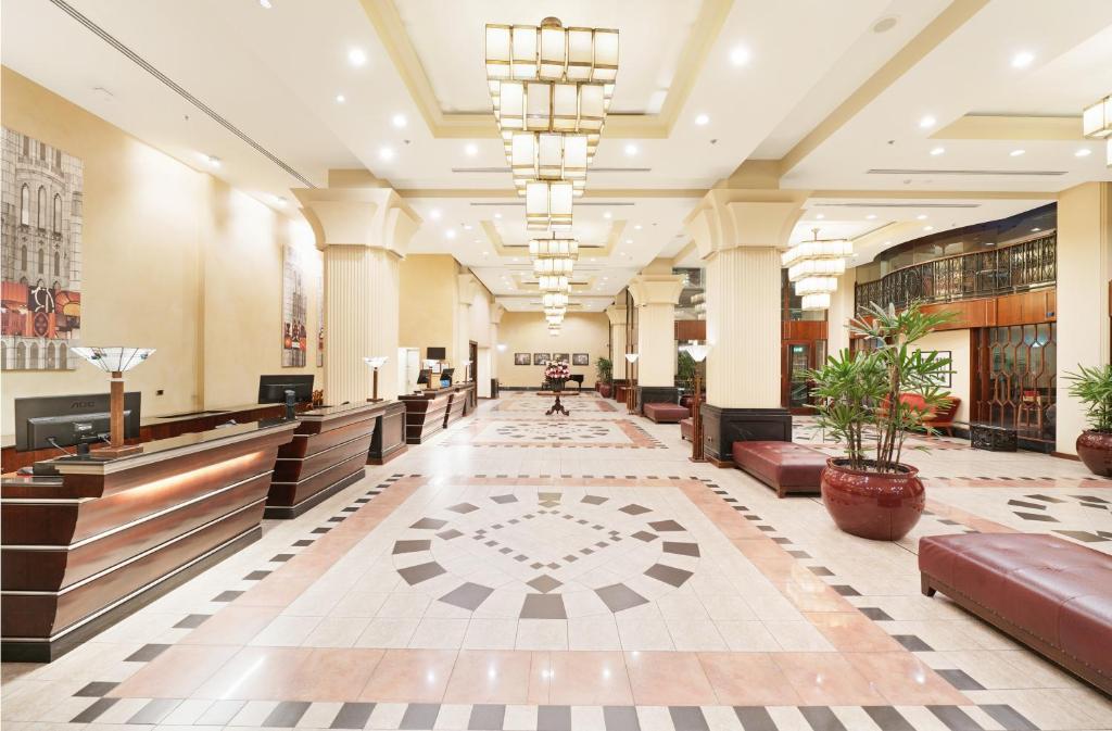 a lobby of a building with benches and potted plants at The Grace Hotel in Sydney