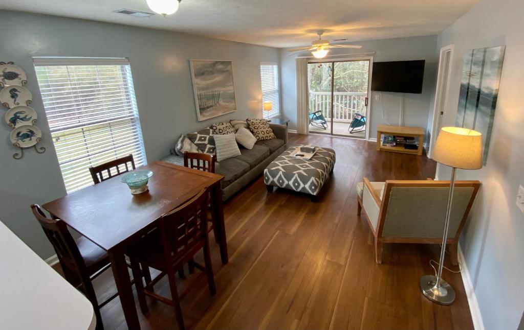 uma sala de estar com um sofá e uma mesa com uma sala de jantar em True Blue Hideaway em Pawleys Island