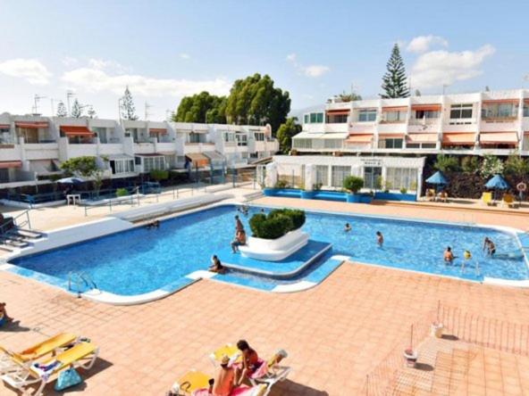 a large swimming pool with people in a resort at Casa Maggiore di 3 lovely apt Costa del Silencio in Costa Del Silencio