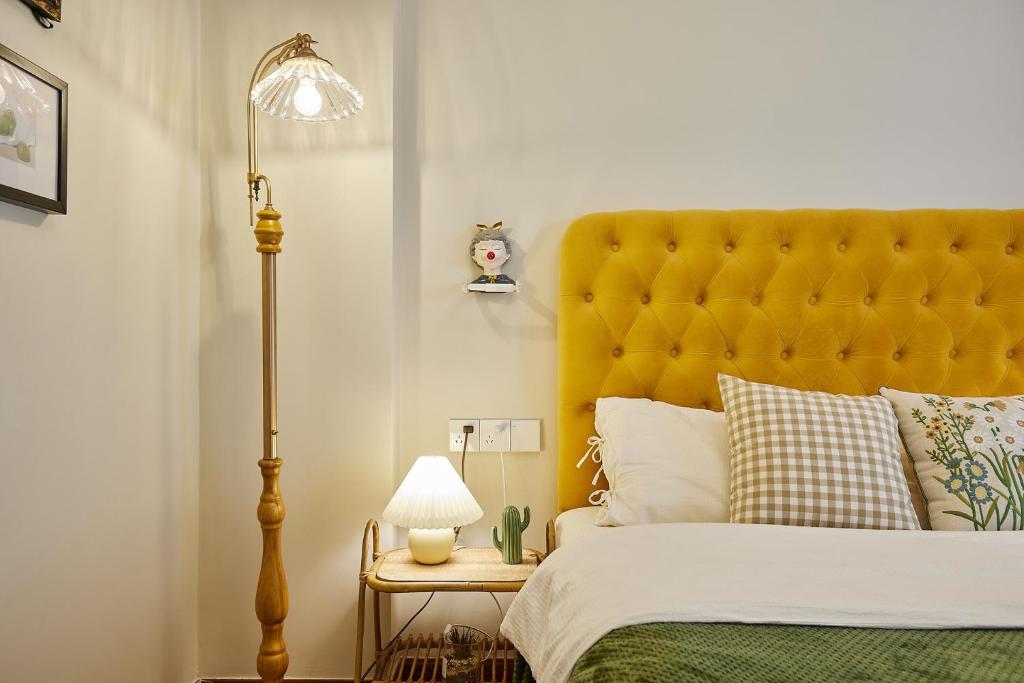 a bed with a yellow headboard in a bedroom at Locals Apartment House 02 in Changsha