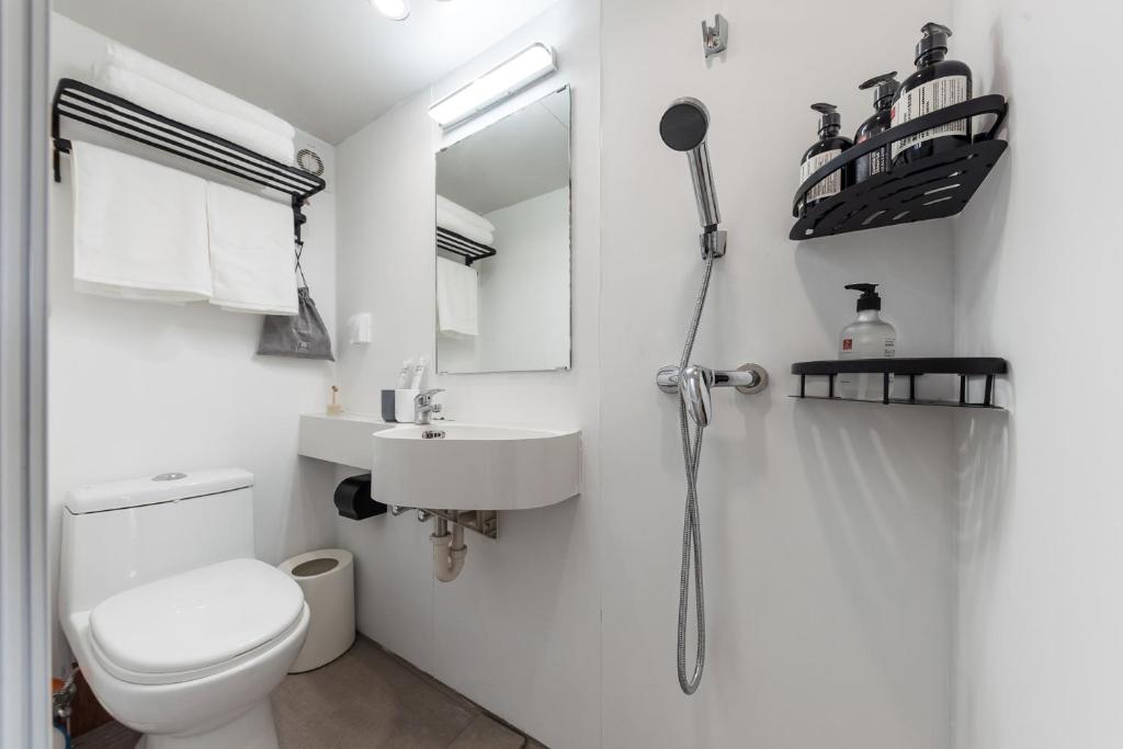a white bathroom with a toilet and a sink at Vanke Apartment Guangzhou South Railway Station Vanke Expo Expo Expo Olympic Park yueshidai square Changlong happy world in Guangzhou