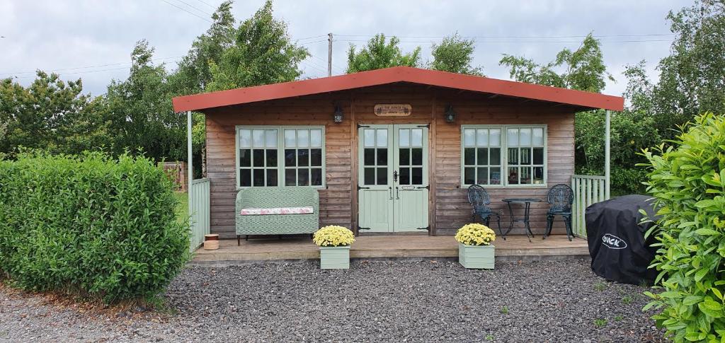 una piccola cabina in legno con tetto rosso di Marshland Alpacas Glamping Lodge a New Holland