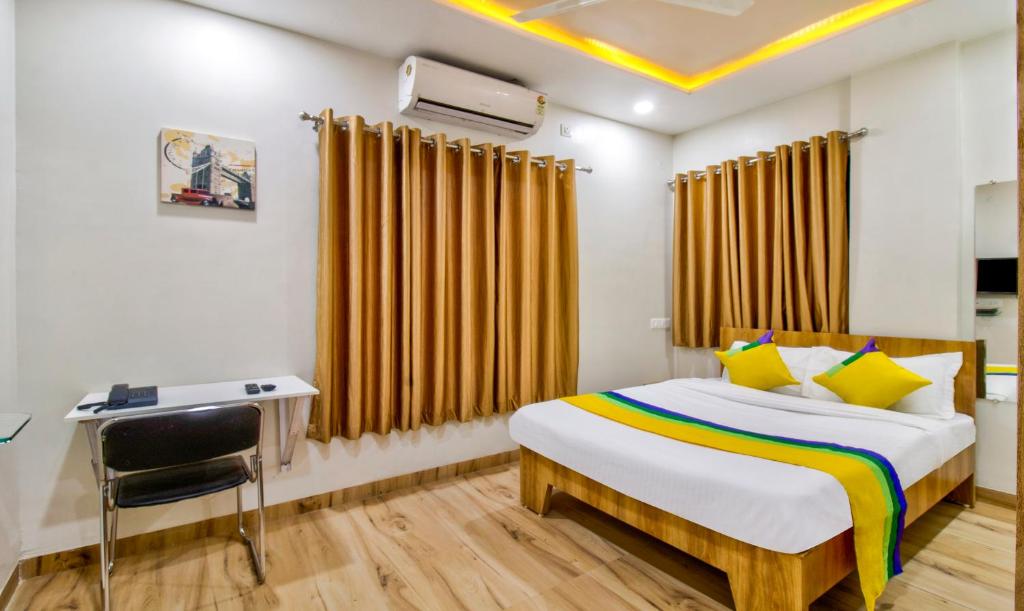 a bedroom with a bed and a desk and a chair at Itsy By Treebo - Shri Guru Service Apartment in Nagpur