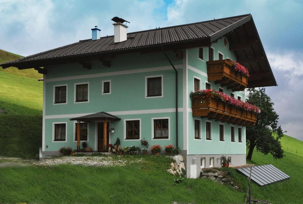 una casa en la cima de una colina verde en Obersteffengut en Wagrain