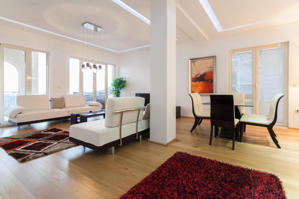 a living room with white furniture and a red rug at Spa Resort Luxury Apartments in Budva