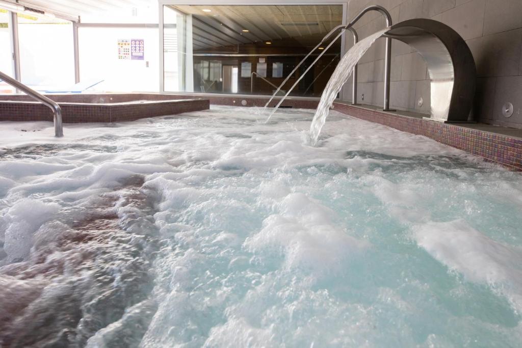 uma banheira de hidromassagem cheia de neve num edifício em Hotel Thalasso Cantabrico Las Sirenas 4 Superior em Viveiro