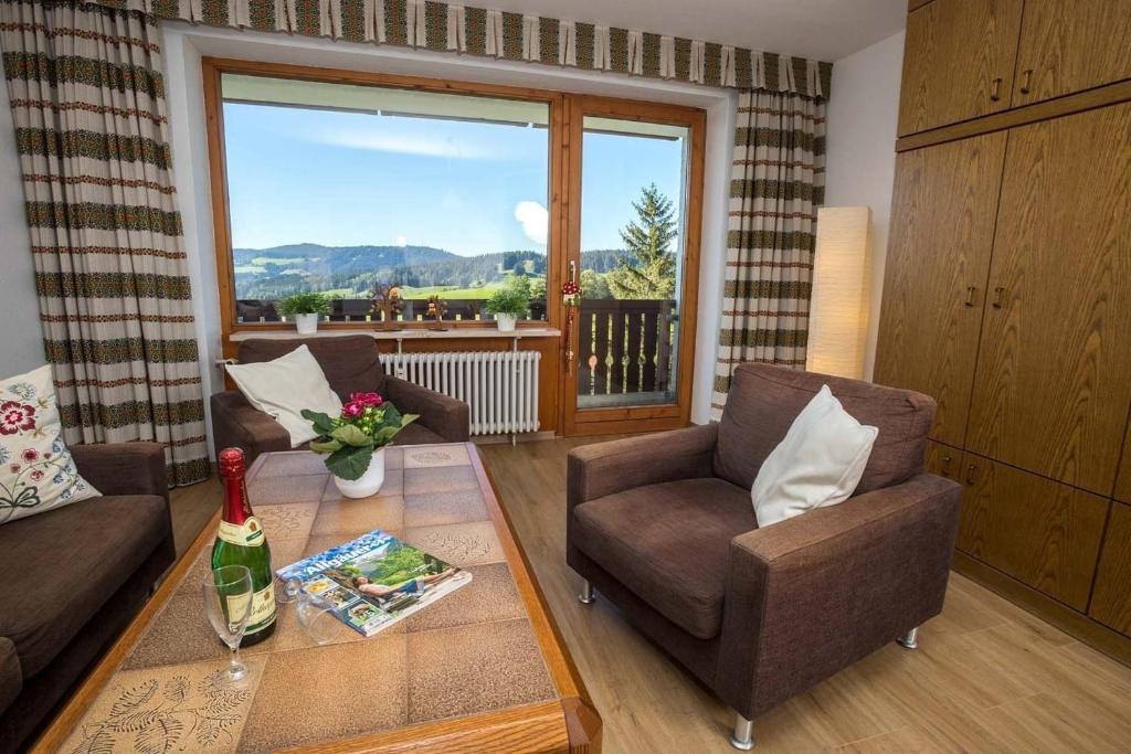 ein Wohnzimmer mit 2 Stühlen, einem Tisch und einem Fenster in der Unterkunft Appartment 1614, Ferienpark Oberallgäu, Schwimmbad, Sauna, Spielplatz in Missen-Wilhams