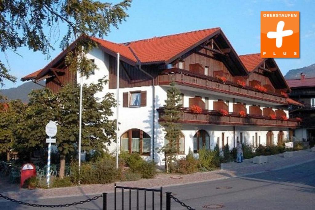 a large building with a red roof on a street at Ferienwohnung Nr 18, Golf- und Ski-Residenz, Oberstaufen-Steibis, Allgäu in Oberstaufen