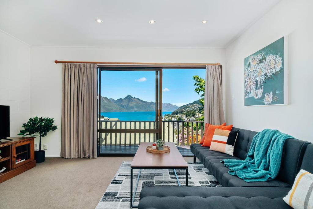 a living room with a couch and a large window at Town Centre Location with Stunning View - Unit 1 in Queenstown