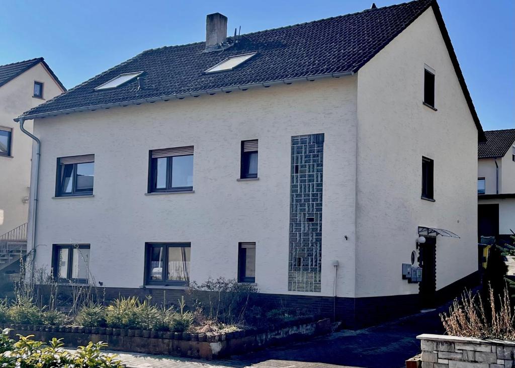 a white house with a black roof at Monteurwohnung - FerienWohnung nähe Limburg an der Lahn in Flacht