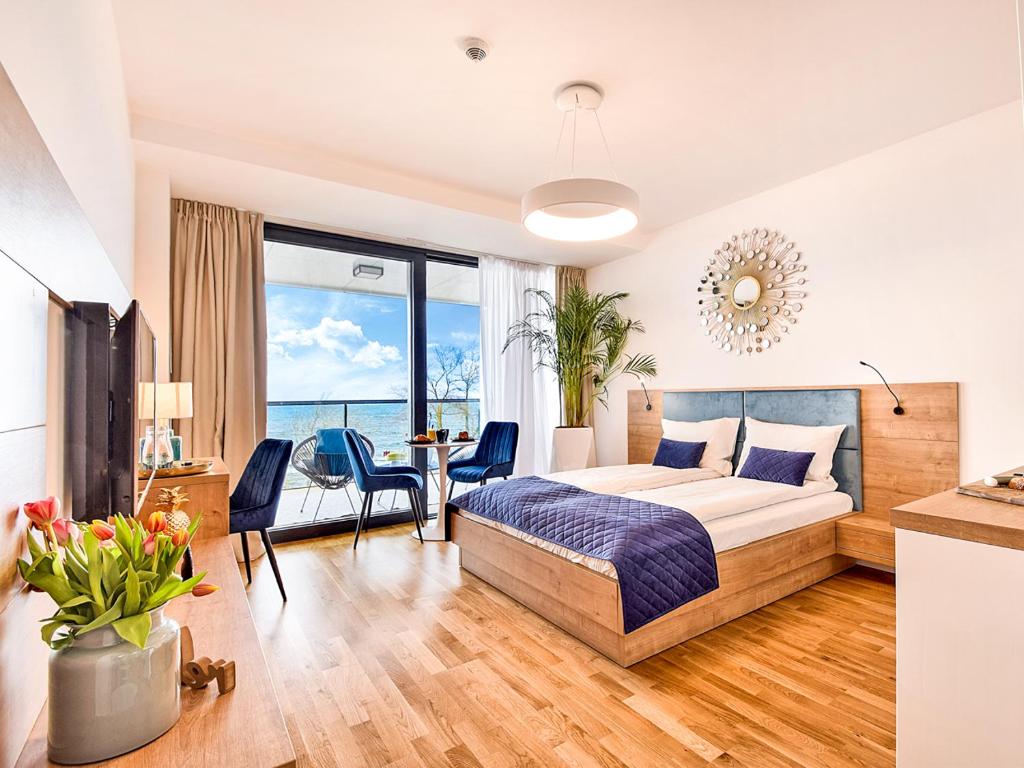 a bedroom with a bed and a table with chairs at NORTH Apartments, SeaView Seaside Park in Kołobrzeg