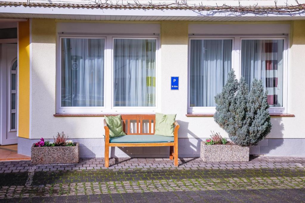 eine Bank vor einem Haus mit zwei Fenstern in der Unterkunft Ferienwohnung 3 Am Petersberg in Neef