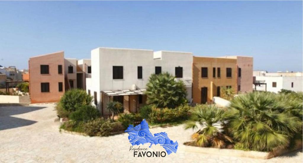 un bâtiment avec un panneau bleu devant lui dans l'établissement Residence Favonio, à Favignana