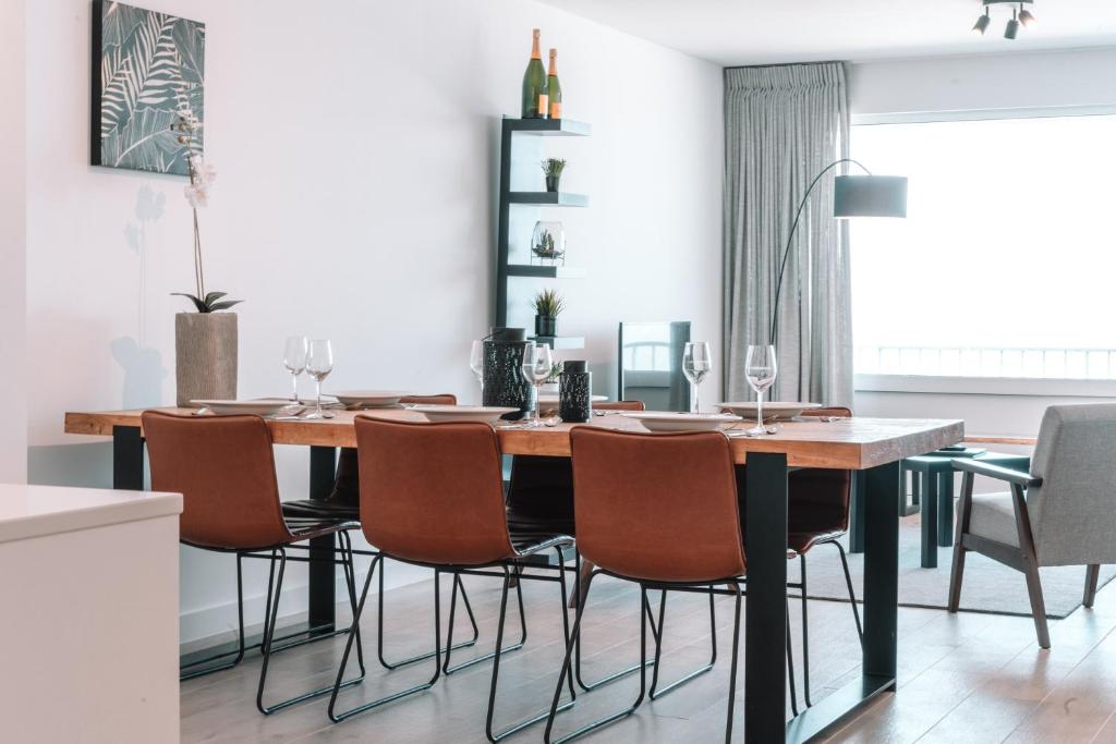 a dining room with a wooden table and chairs at Appartement Godderis I, 9de verdieping in Blankenberge
