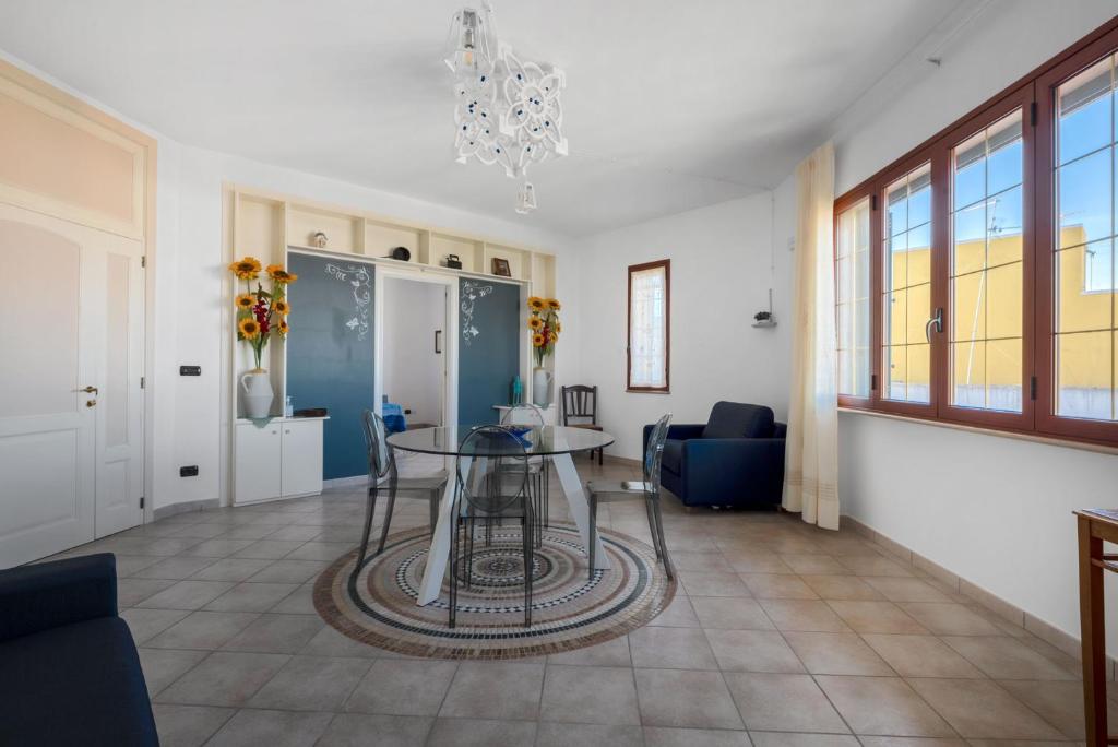 un soggiorno con tavolo e sedie in vetro di Apartments Alba Lilia - Puglia Salento a Nociglia