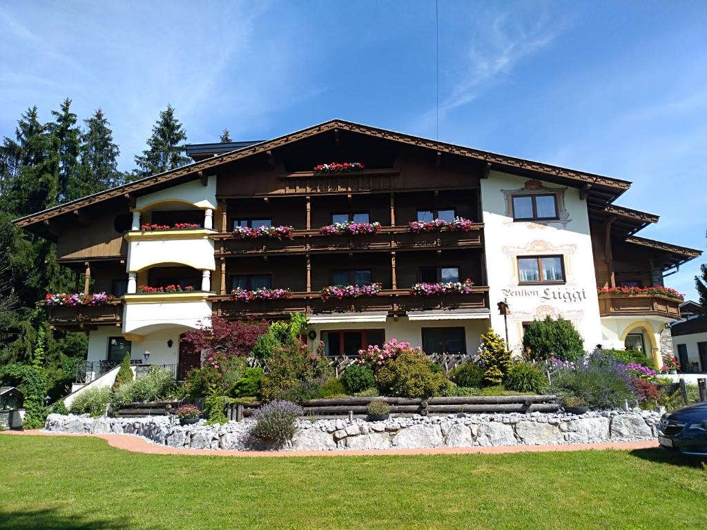ein großes Gebäude mit Blumen auf den Balkonen in der Unterkunft das Luggi Appartements in Reith im Alpbachtal
