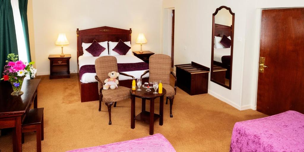 
a hotel room with two beds and a table at Lawlors Hotel in Dungarvan
