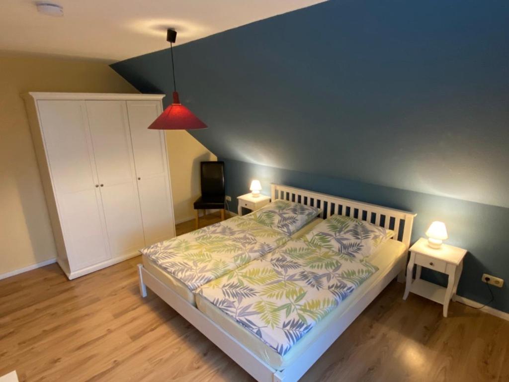 a bedroom with a bed with two night stands and two lamps at Ferienwohnungen Koch OG adult only in Wangerland