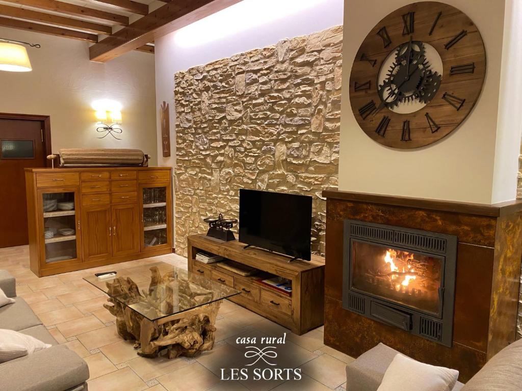 - un salon avec une cheminée et une grande horloge dans l'établissement Casa rural Les Sorts, à Rosell