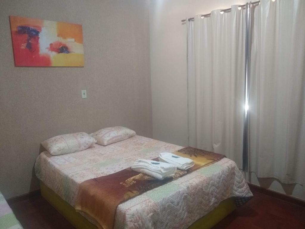 Pousada do Ribeirão في Andrelândia: غرفة نوم عليها سرير وفوط